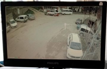 Köy yerleşimindeki geniş araç ve yol alanını gösteren güvenlik kamerası