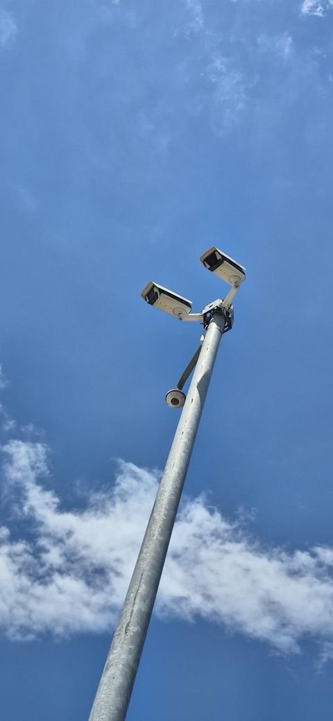 Yüksek direk üzerinde farklı yönlere bakan dış ortam güvenlik kameraları